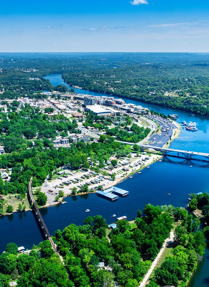 Ariel view of Lake Taneycomo in Branson, Missouri showing many docks and two bridges going across the lake. 