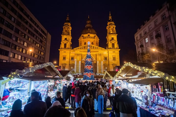 People exploring a Christmas Market in Budapest at Night. 