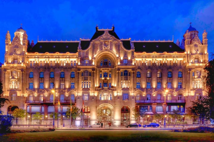 Entrance to the Four Seasons Hotel In Budapest lit up at night with lights.