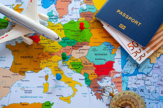 Colorful map of Europe with a passport and airplane laying on top of it.
